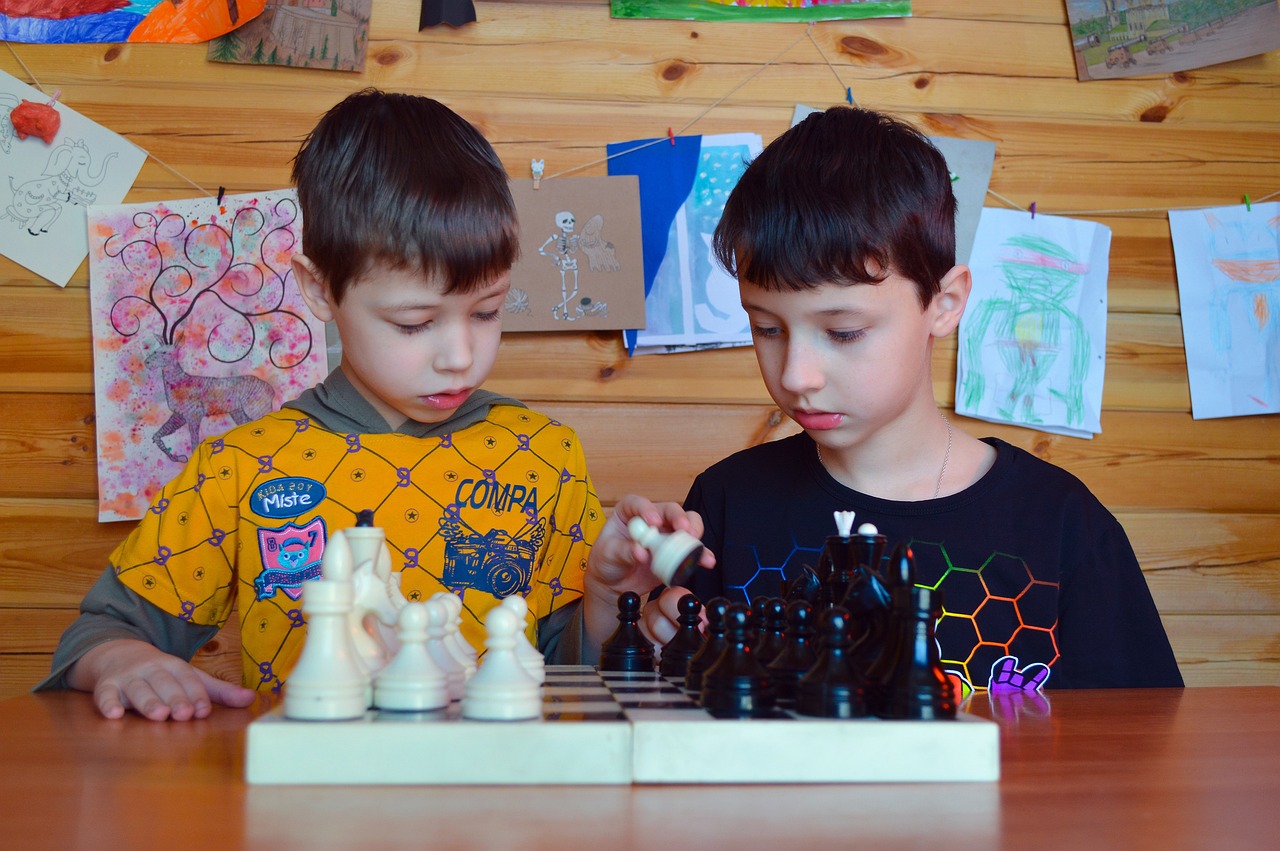 Two young boys playing chess together